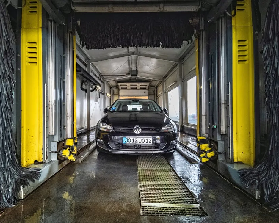 Spinning brushes inside an automatic car wash tunnel contacting a vehicle