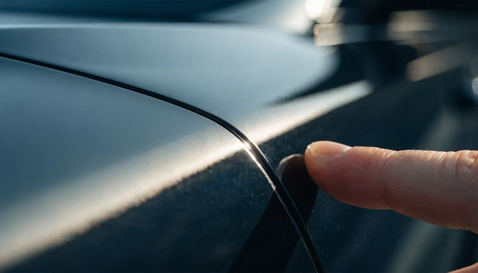 Close-up of water beading on a freshly coated dark vehicle hood