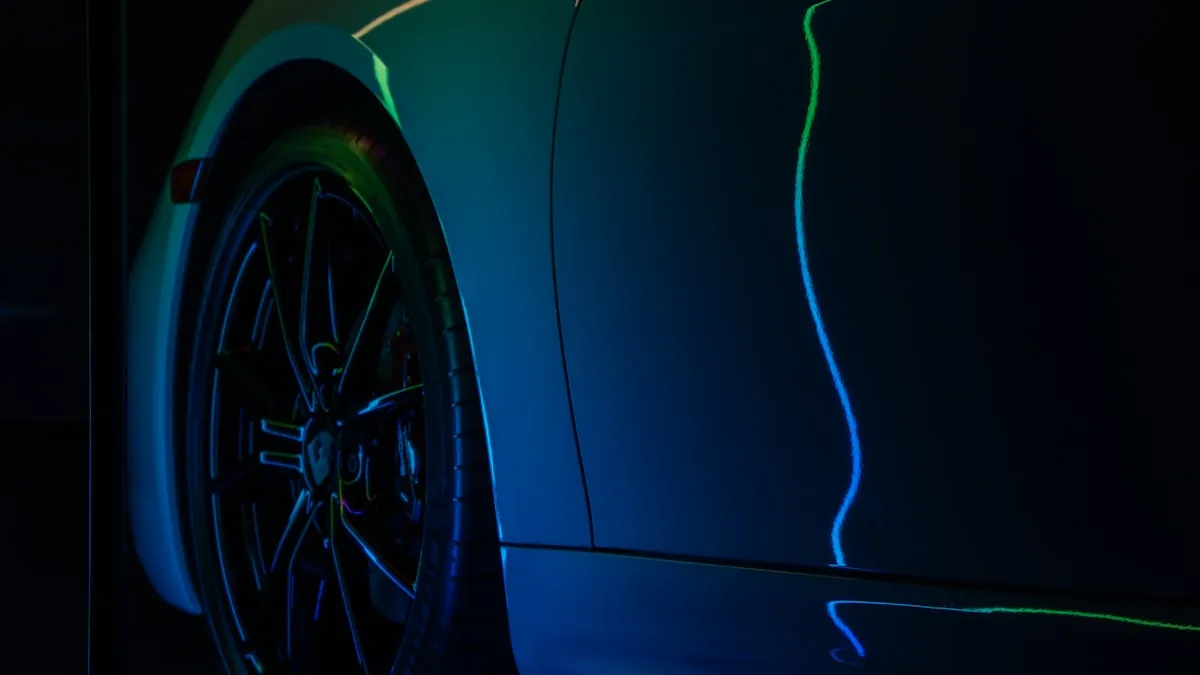 Professional installer using a heat gun to conform PPF around a vehicle's curved body panel edge
