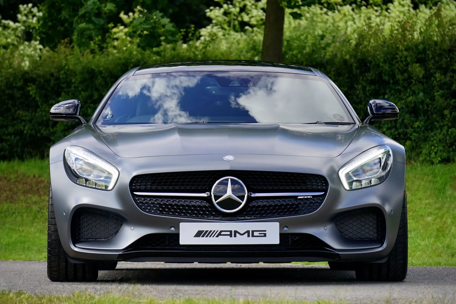 luxury sedan parked outdoors beside trees